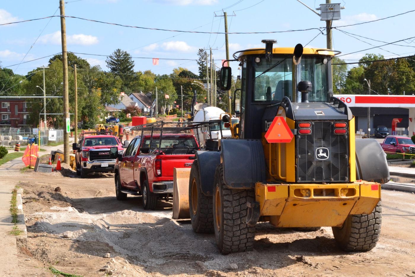 Earthmoving machinery and trucks working on a road construction site — reference photo