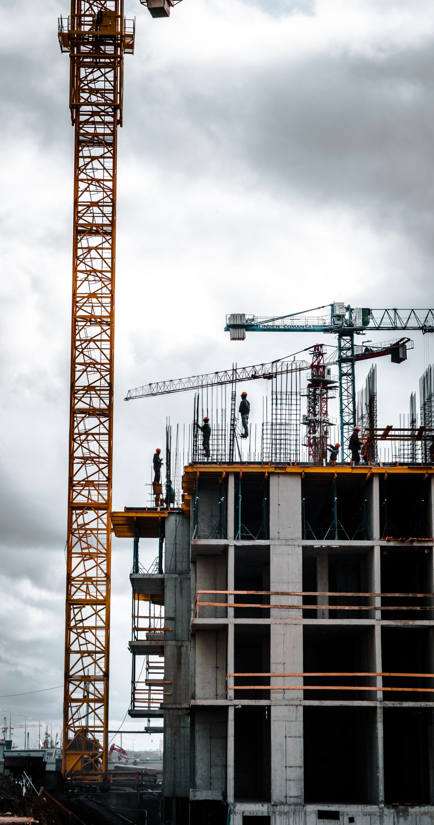Crane alongside a multistorey building under construction — reference photo