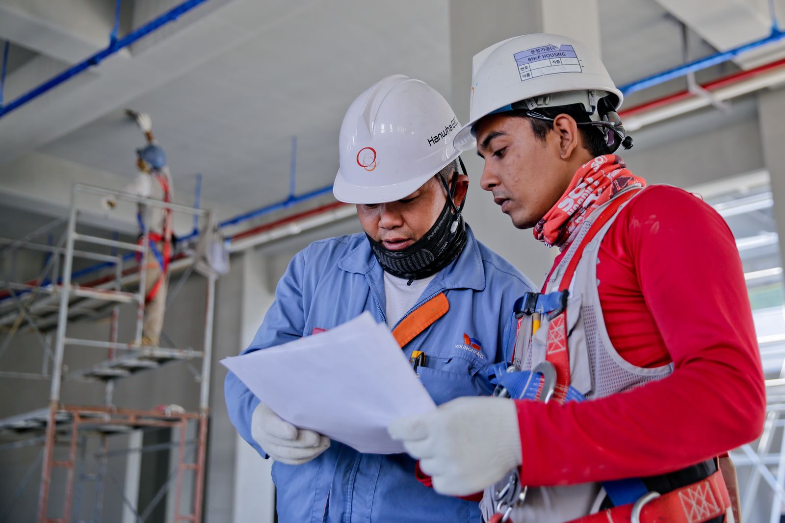 BS Rajput Contractor site workers in hard hats reviewing plans on a construction site